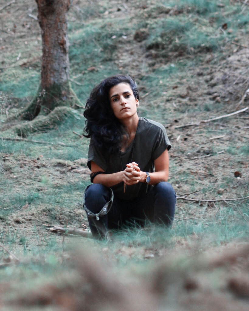 Deniz Celebi, die türkische Künstlerin und Musikerin aus Stuttgart sitzt im Wald
